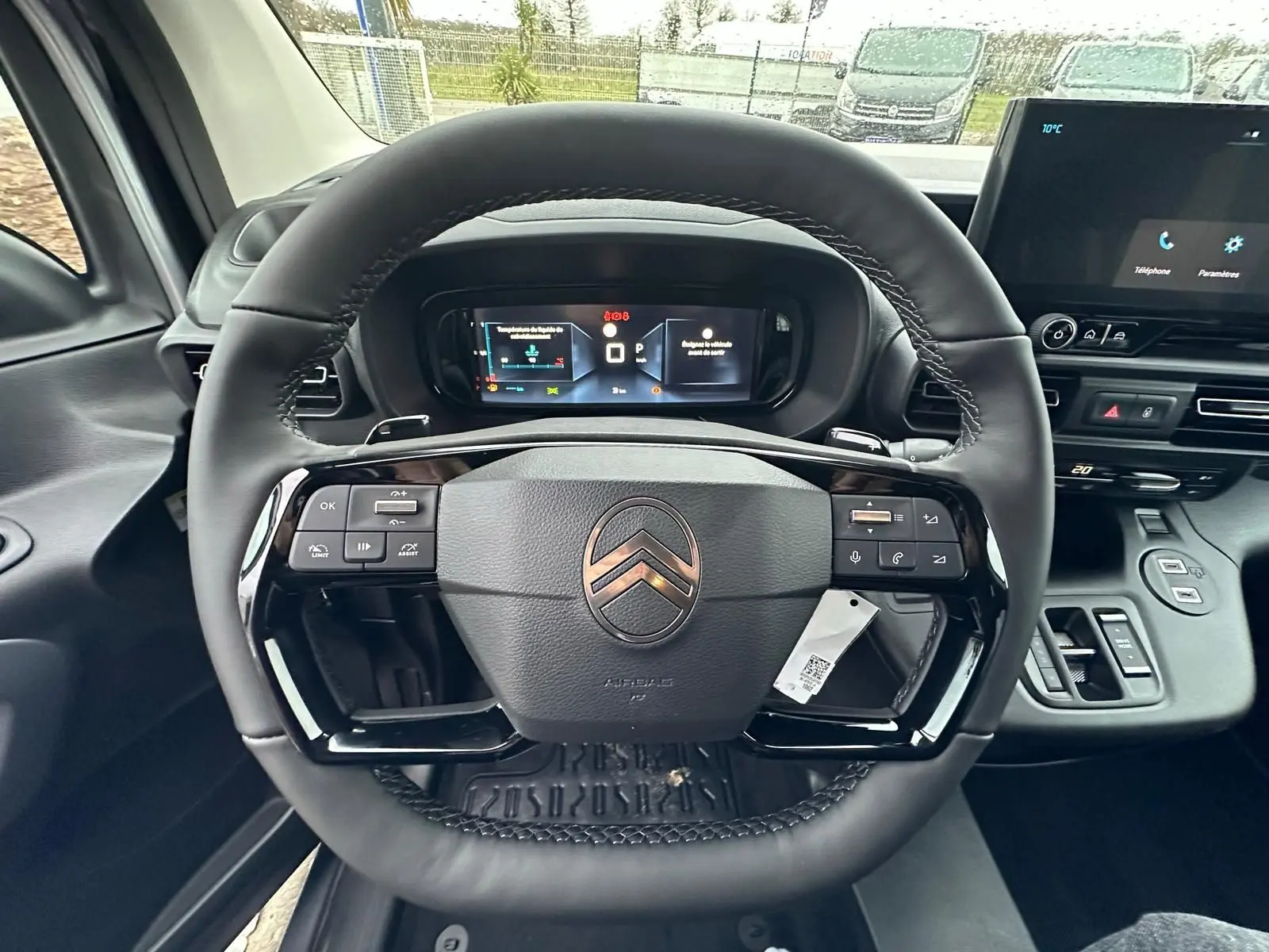 Vue rapprochée du volant cuir noir du Citroën Berlingo 2025 avec tableau de bord numérique et écran central tactile.