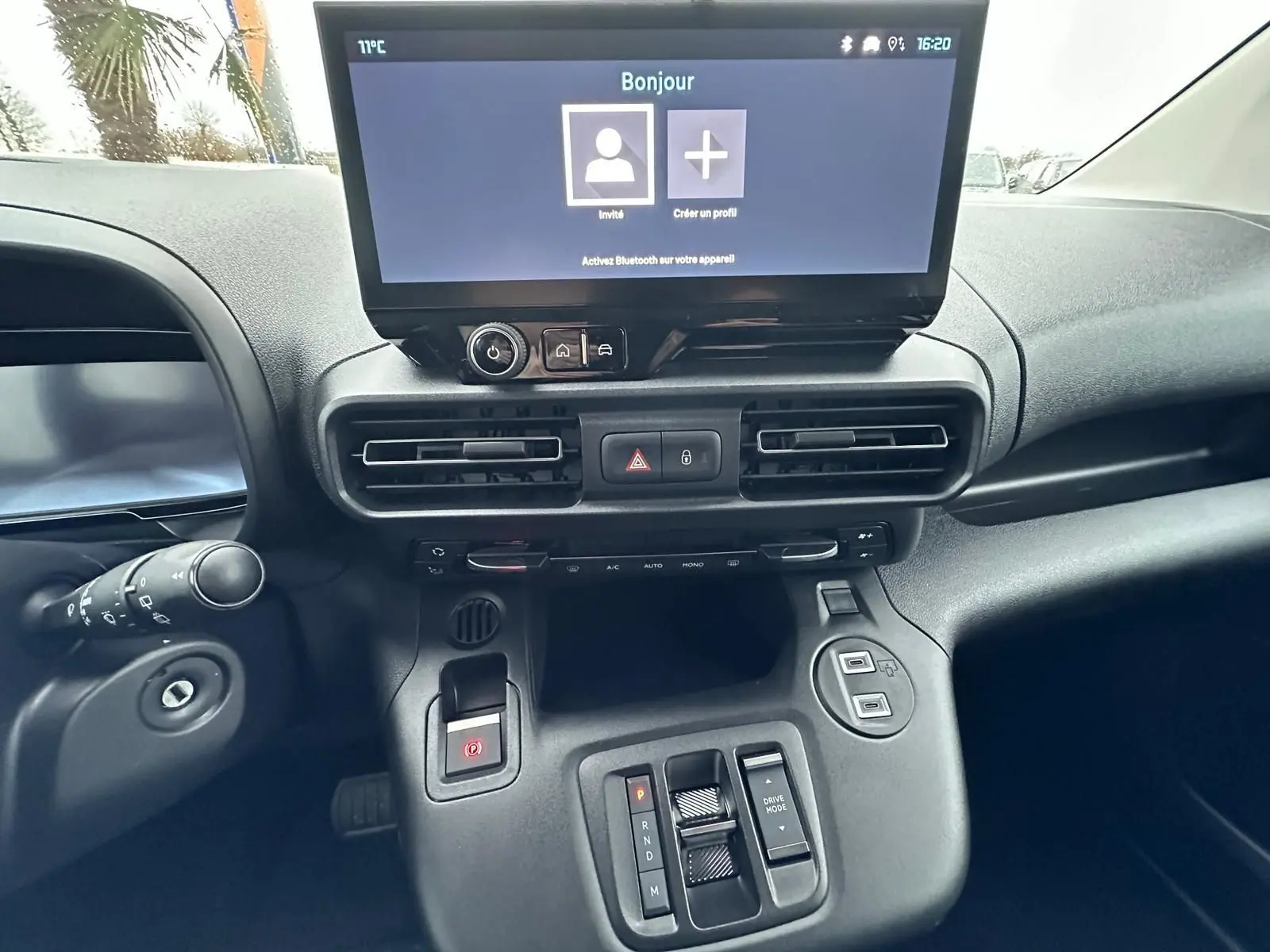 Vue rapprochée du tableau de bord du Citroën Berlingo 2025 gris Artense, avec écran tactile et commandes de boîte automatique.