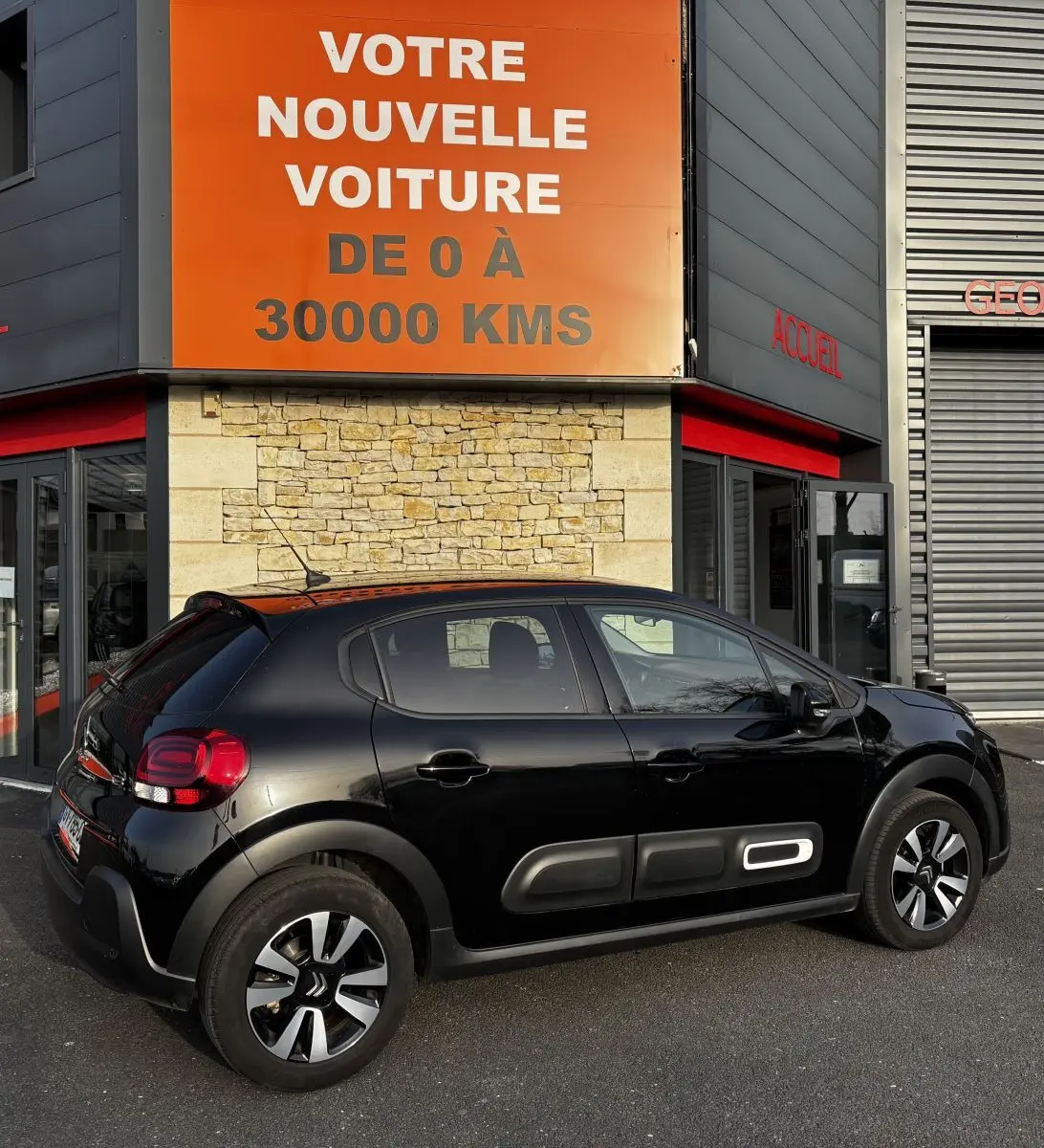 Vue latérale droite d'une Citroën C3 noire 2024 avec protections latérales distinctives et jantes bicolores.