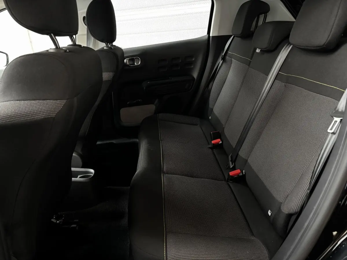 Vue intérieure arrière côté droit de la banquette noire avec ceintures et appuie-têtes du Citroën C3 2024 PureTech Shine.
