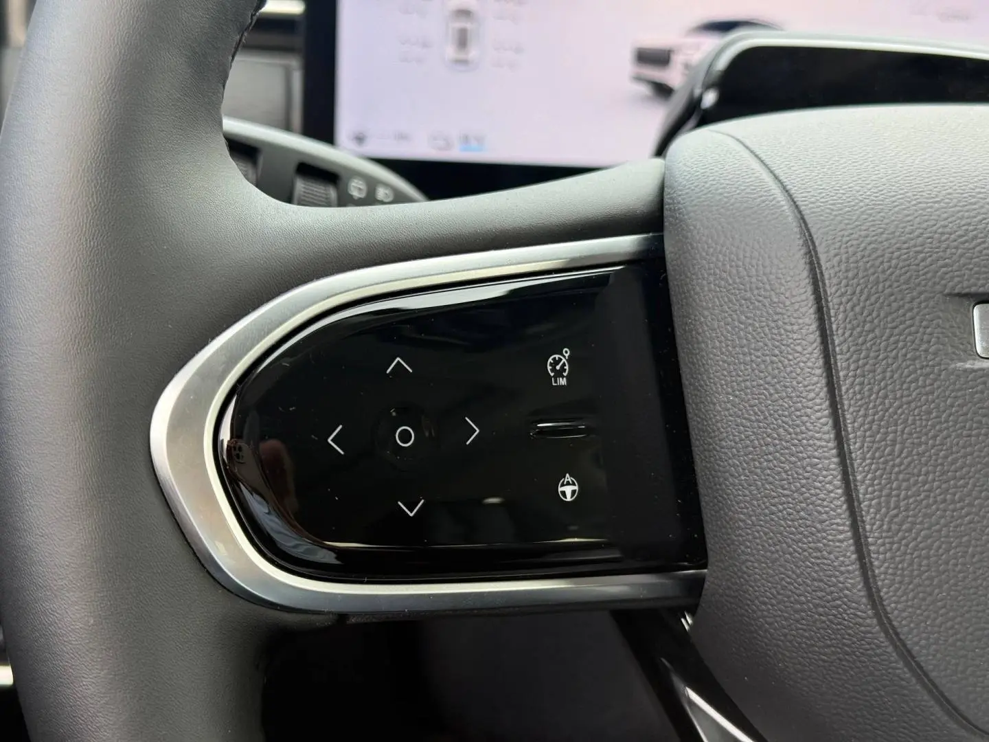 Gros plan sur les commandes multifonctions à gauche du volant noir du JAECOO J7 blanc, version 2026.