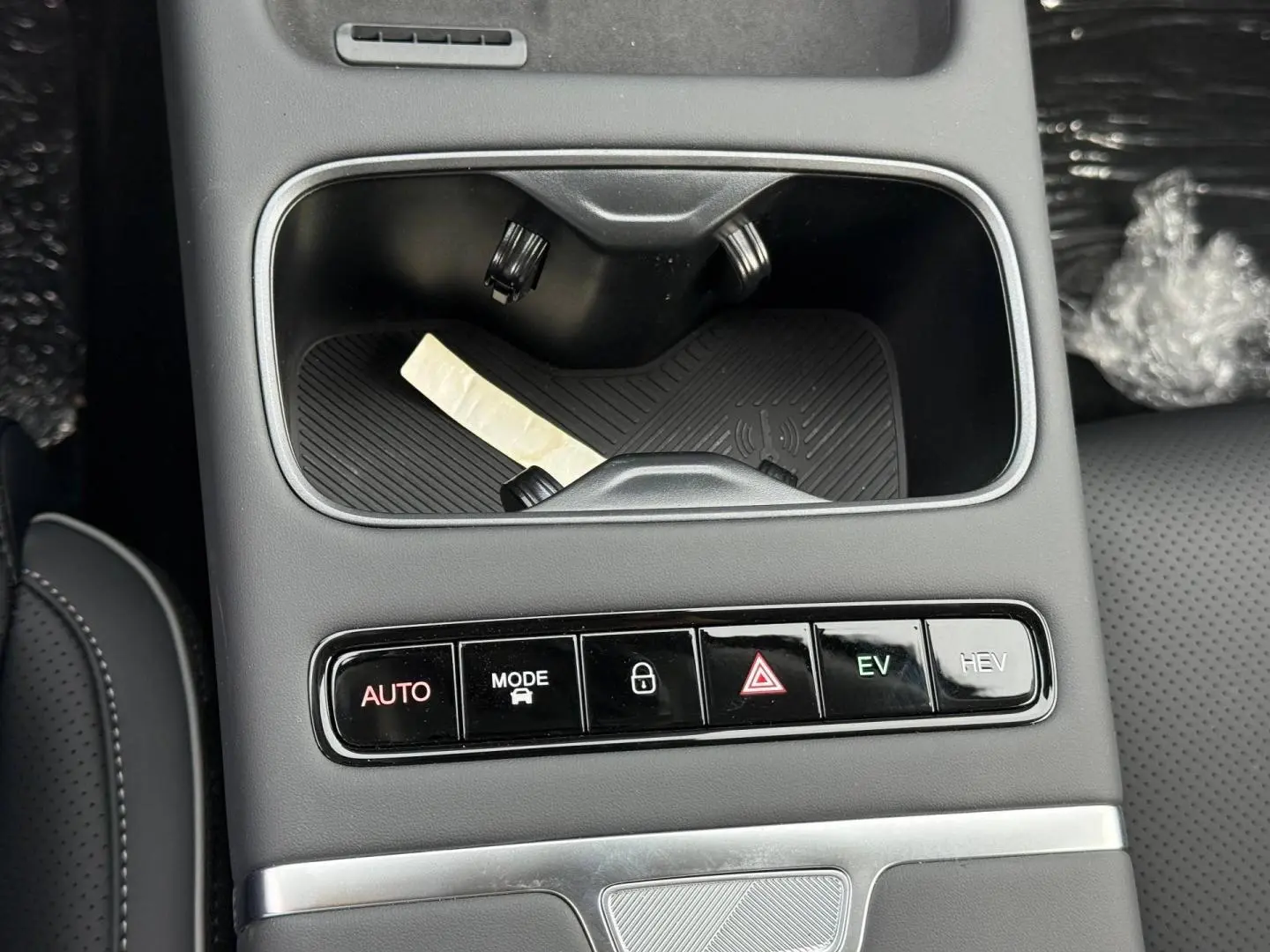 Gros plan sur la console centrale noire du JAECOO J7 avec boutons de modes de conduite et porte-gobelets.
