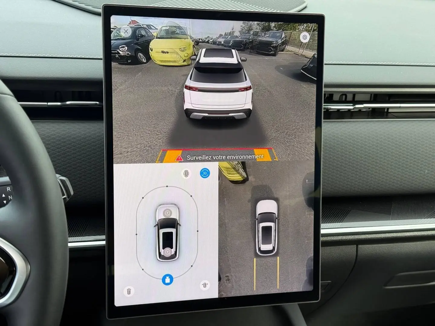 Écran tactile intérieur montrant la vue 360° et arrière d’un SUV JAECOO J7 blanc en stationnement.