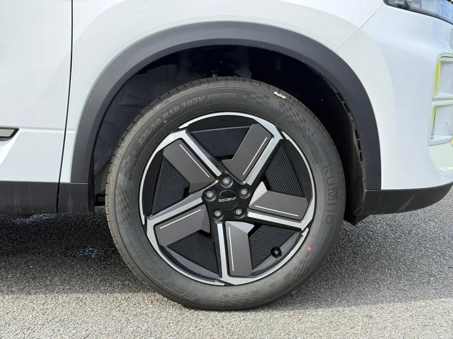 Gros plan sur la roue avant gauche de la JAECOO J7 blanche avec jante alu au design moderne.