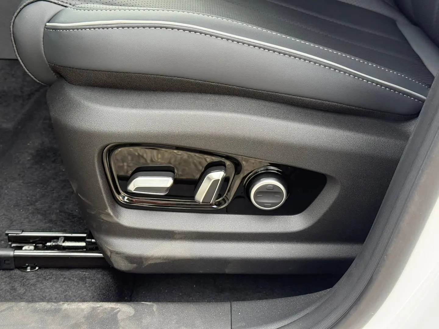 Réglages électriques du siège conducteur en similicuir noir dans le JAECOO J7 blanc, vue côté gauche.