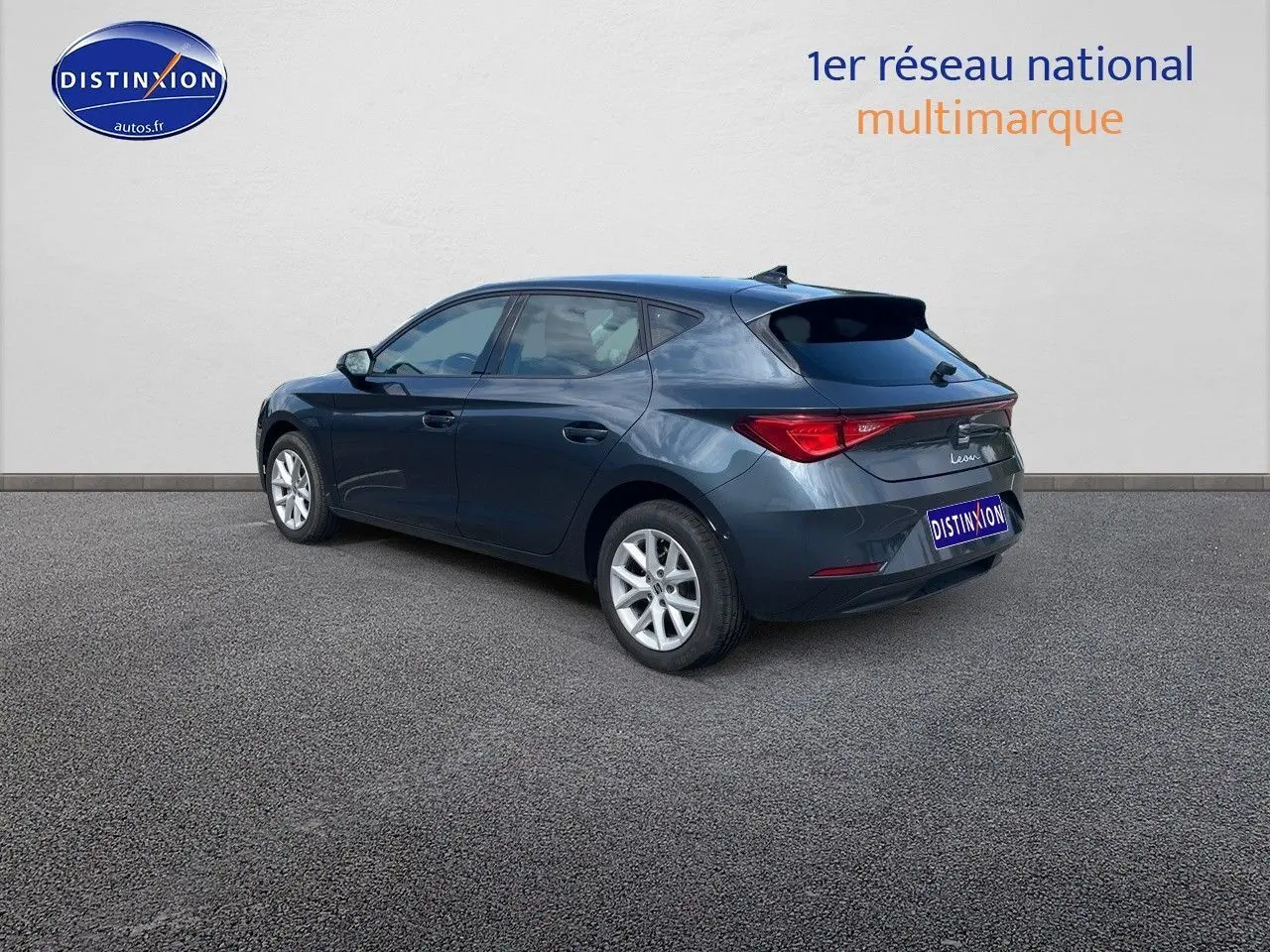 Vue 3/4 arrière droite d'une SEAT Leon gris magnétique métal 2024 avec feux LED et jantes argentées.