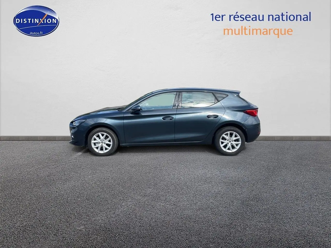 Profil côté gauche d'une SEAT Leon IV 1.5 TSI gris magnétique métal avec jantes alliage et cinq portes visibles.