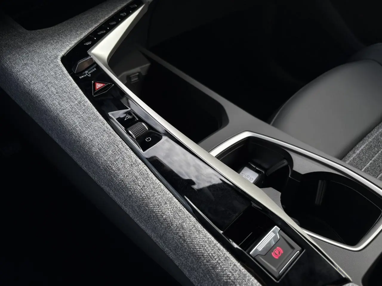 Gros plan sur la console centrale tissu gris et la commande de frein électrique du Peugeot 5008 Hybrid blanc Okénite.