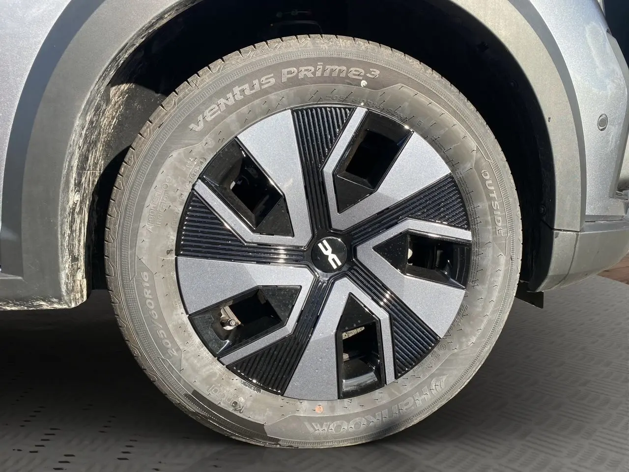 Gros plan sur la roue avant droite de la Dacia Sandero Stepway gris schiste avec jante noire et grise design moderne.