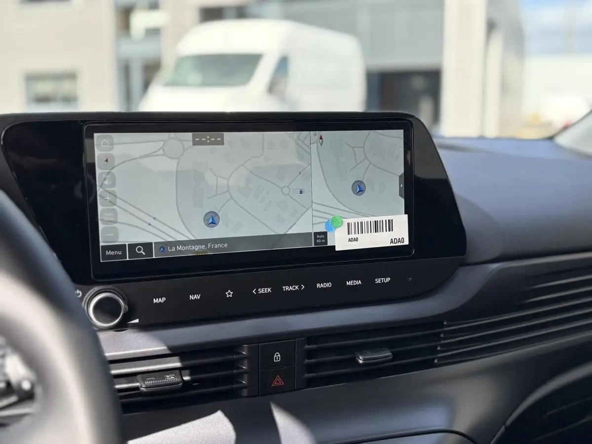 Écran tactile central du tableau de bord de la Hyundai i20 2026, affichant la navigation avec carte et commandes intégrées.