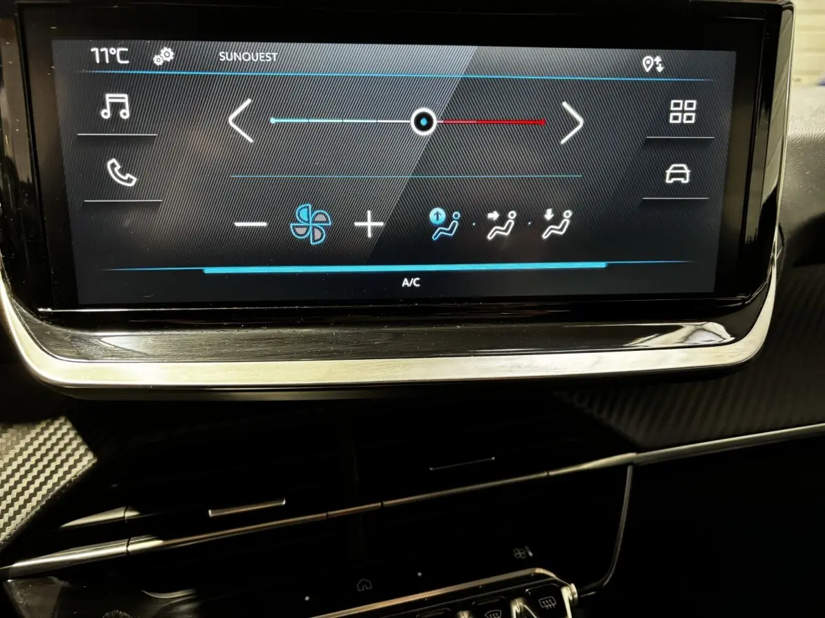 Écran tactile central affichant les commandes de climatisation dans l’habitacle d’une Peugeot 208 gris clair 2024.