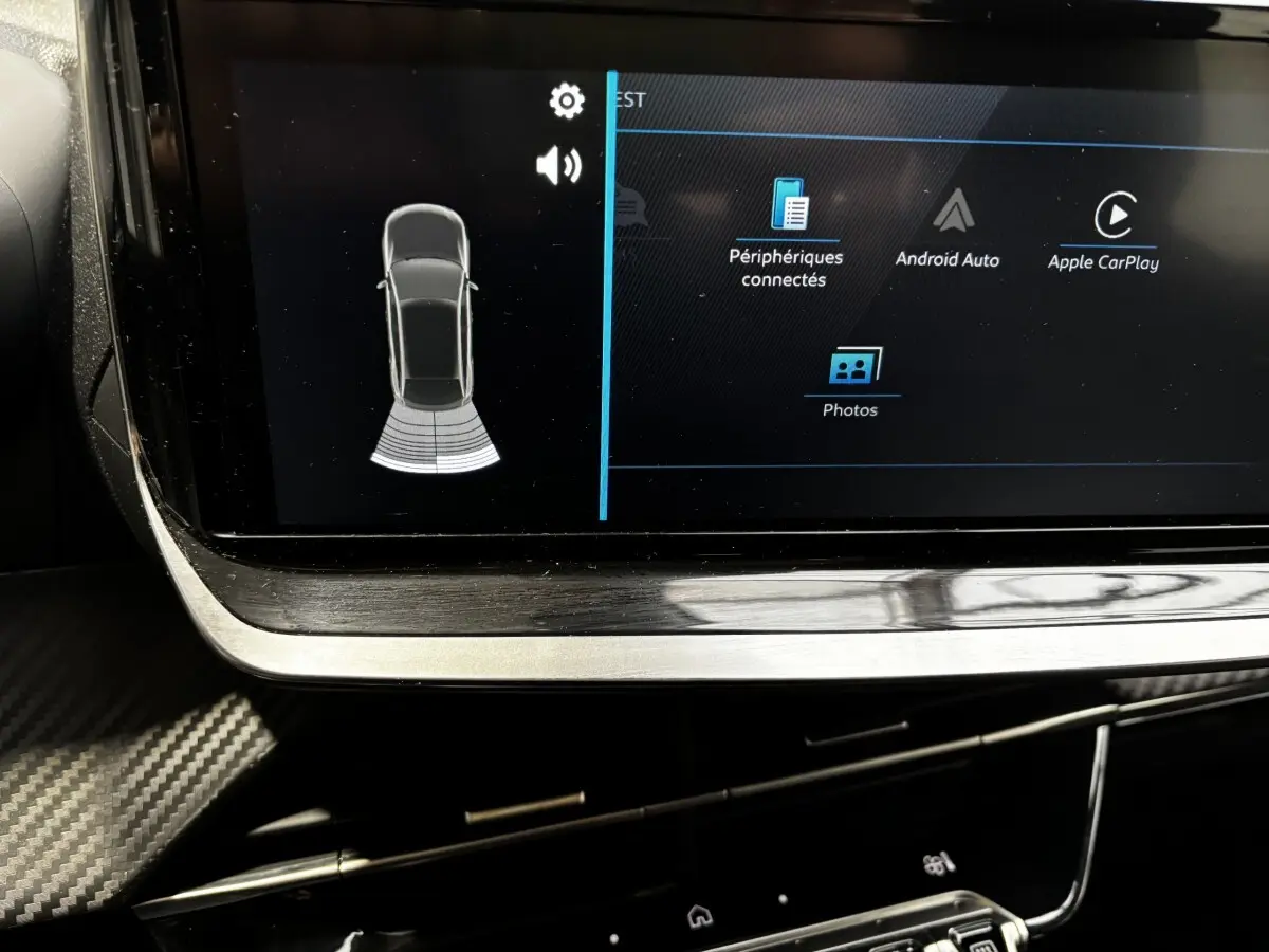 Gros plan sur l'écran tactile central de la Peugeot 208 gris clair, affichant les options Android Auto et Apple CarPlay.