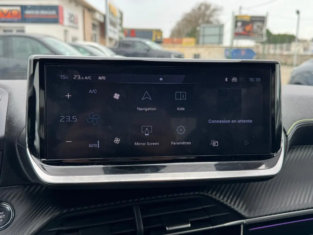 Écran tactile central du tableau de bord de la Peugeot 208 gris, affichant les options de navigation et climatisation.
