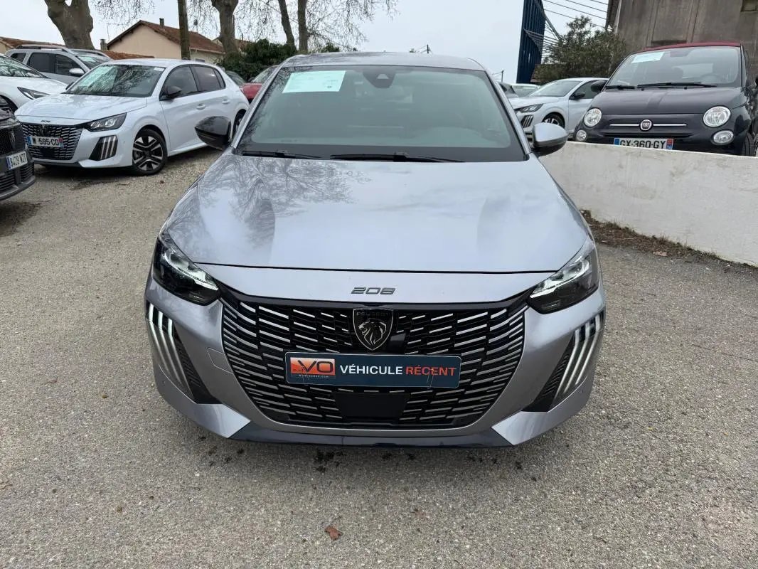 Vue avant frontale d'une Peugeot 208 Hybrid 110 gris avec calandre noire et feux LED distinctifs.