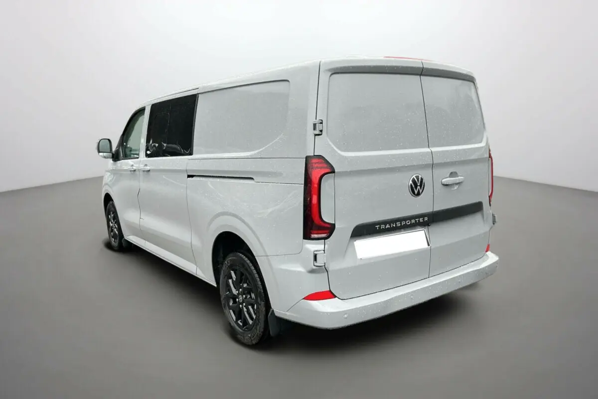Vue 3/4 arrière droite d’un Volkswagen Transporter Stone Grey avec jantes alu noires et vitres teintées.