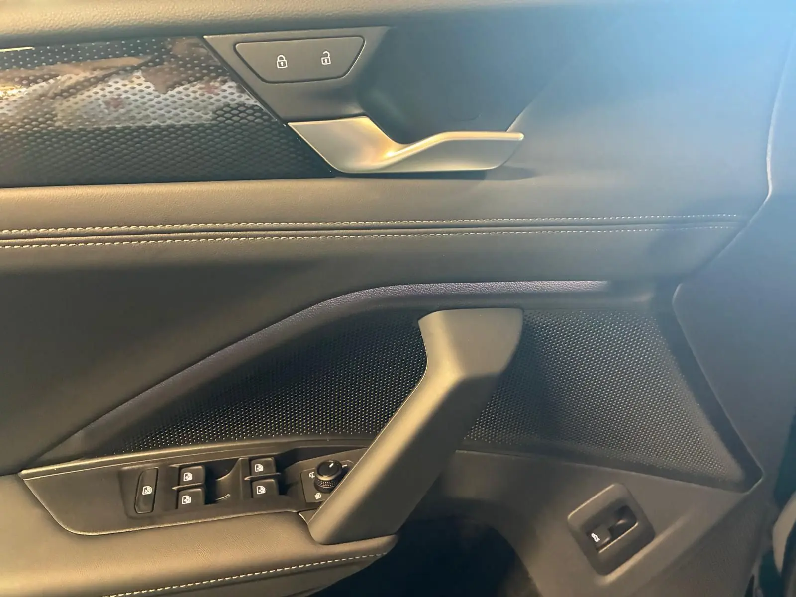 Détail de la porte côté conducteur du Volkswagen Tiguan 2026 noir Grenadilla avec commandes de vitres et verrouillage.