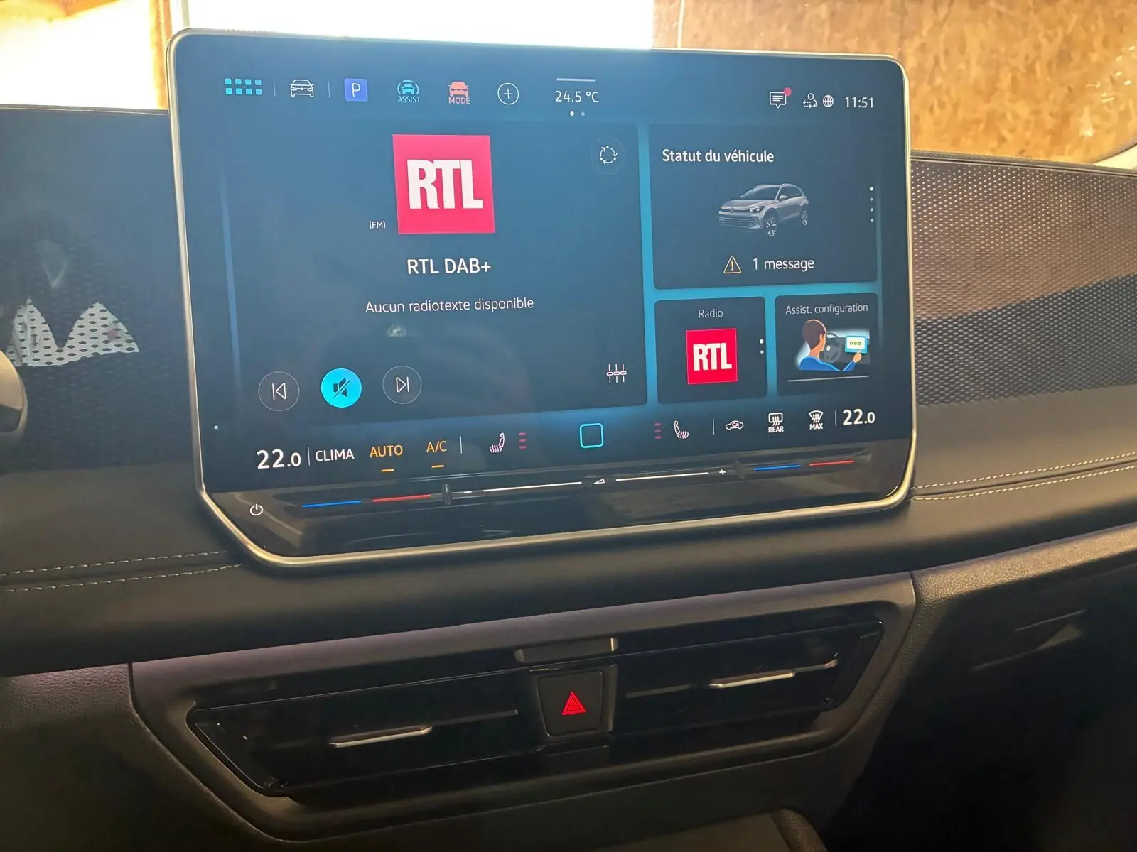 Vue rapprochée de l’écran tactile central du Volkswagen Tiguan noir Grenadilla 2026 avec interface radio RTL et climatisation affichée.
