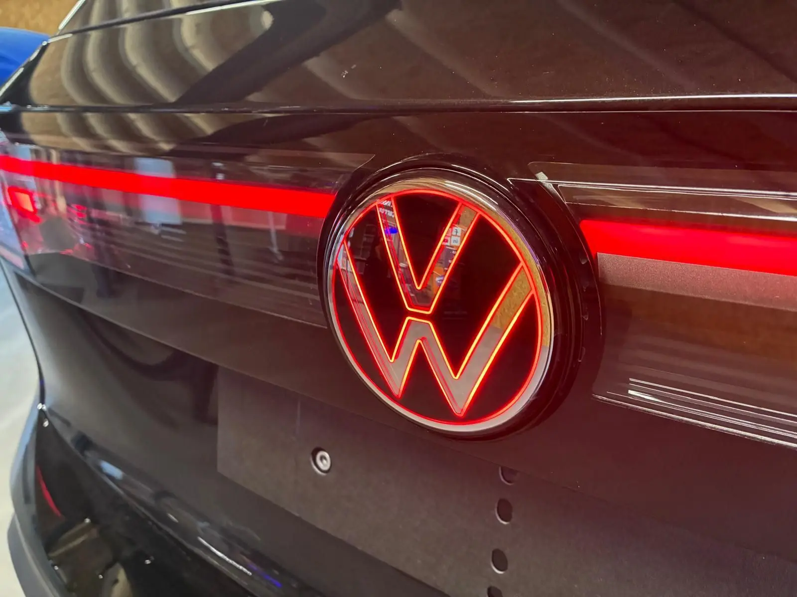 Gros plan sur l'arrière noir grenadilla métal du Volkswagen Tiguan 2026 avec logo VW lumineux rouge et bande LED.