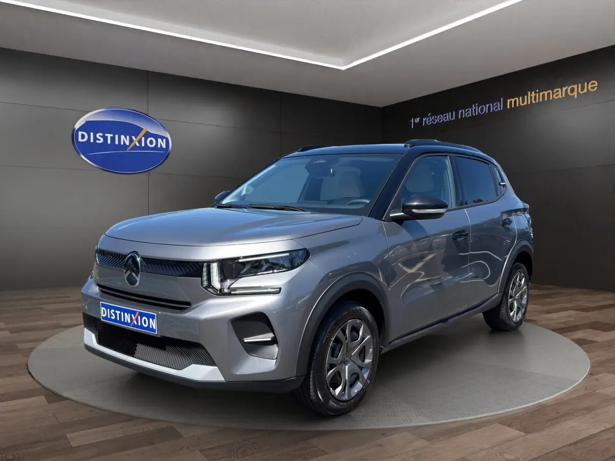 Citroën C3 hybride gris foncé vue 3/4 avant droite avec jantes alliage et toit noir en showroom.