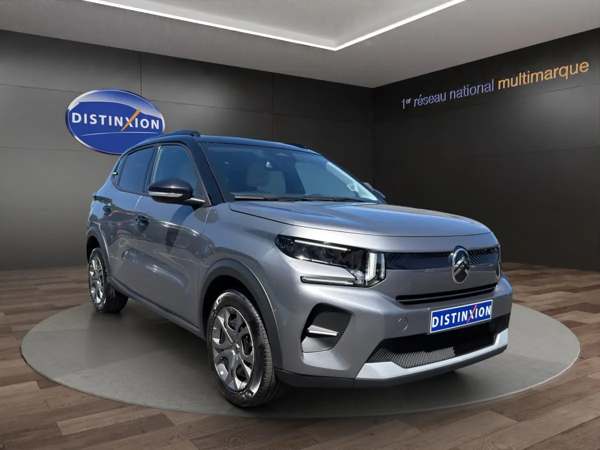 Citroën C3 hybride gris foncé vue 3/4 avant droit, avec phares LED et jantes alliage distinctives.