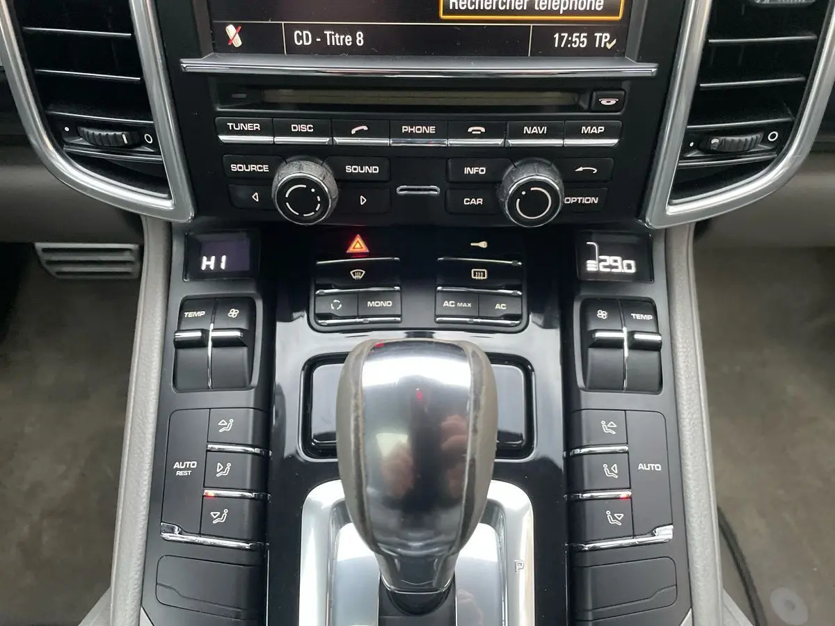 Vue rapprochée de la console centrale grise du Porsche Cayenne S Hybrid 2010 avec levier de vitesses automatique et commandes climatisation.