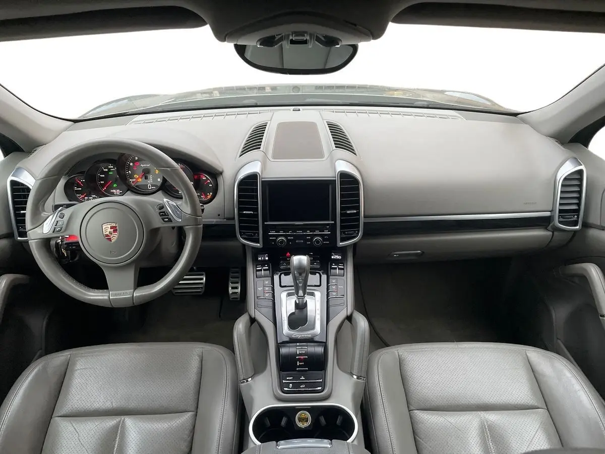 Intérieur gris du Porsche Cayenne S Hybrid 2010 vu de face, avec tableau de bord et console centrale détaillés.