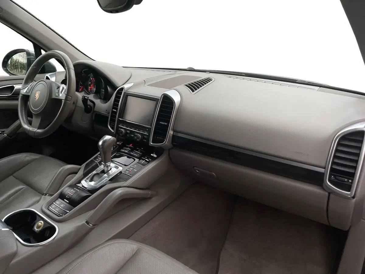 Intérieur gris du Porsche Cayenne S Hybrid 2010 vu côté passager, avec tableau de bord et console centrale élégants.