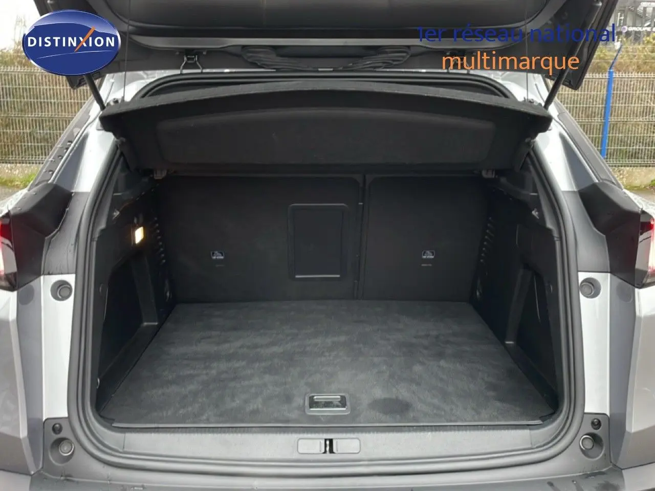 Vue arrière du coffre ouvert du Peugeot 3008 gris Artense Metal, montrant un espace de chargement spacieux et propre.