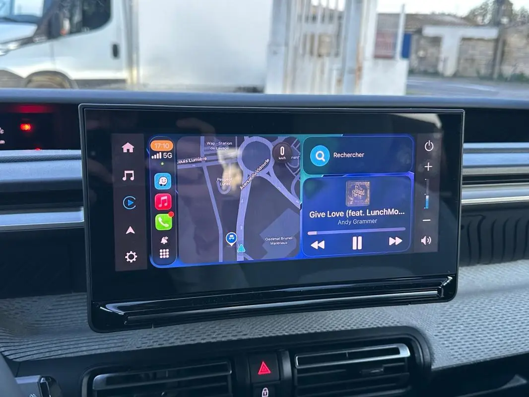 Vue rapprochée de l’écran tactile central du tableau de bord de la Citroën C3 noire, affichant la navigation et la musique.
