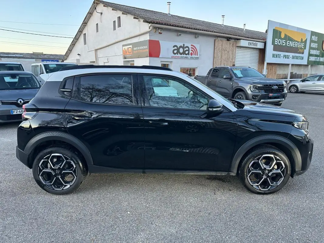 Profil latéral droit d'une Citroën C3 noire 2025 avec jantes alliage 17 pouces et barres de toit visibles.