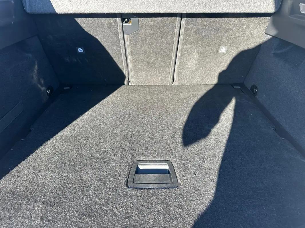 Vue intérieure du coffre spacieux et vide du Peugeot 3008 Hybrid 145 e-DCS6 Allure, revêtement en tissu gris.