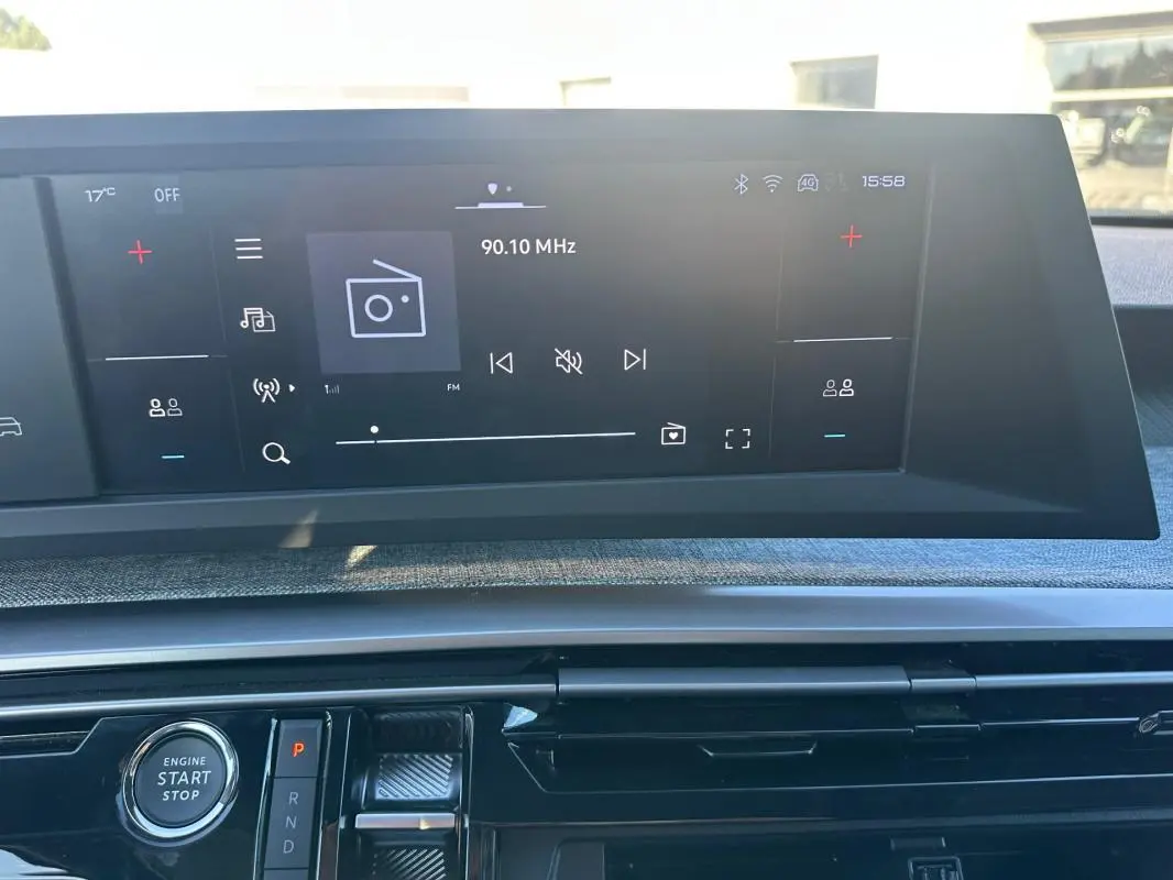 Vue rapprochée de l’écran tactile et de la console centrale du Peugeot 3008 Hybrid blanc, mettant en valeur le bouton start/stop.
