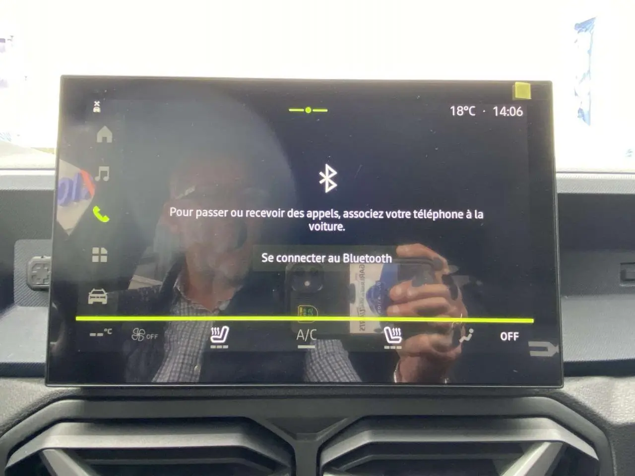 Écran tactile central du Dacia Duster 2025 affichant la connexion Bluetooth, avec commandes climatisation visibles en dessous.