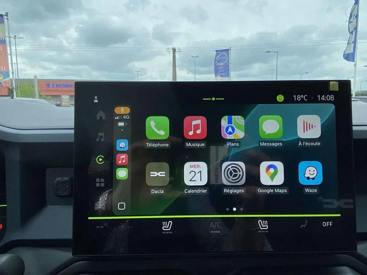 Intérieur du Dacia Duster 2025 montrant l'écran tactile central avec interface connectée et commandes de climatisation.