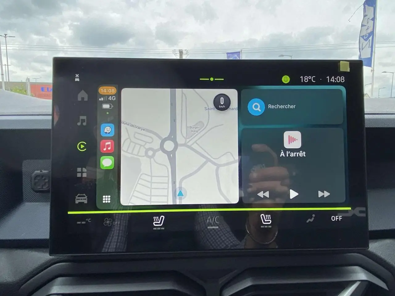 Écran tactile central du Dacia Duster 2025 affichant la navigation et les commandes de climatisation, intérieur noir.