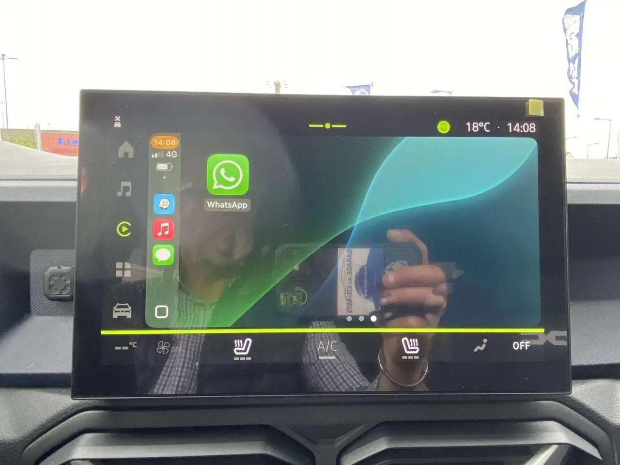Écran tactile central du tableau de bord du Dacia Duster 2025, affichant l’interface multimédia avec WhatsApp.