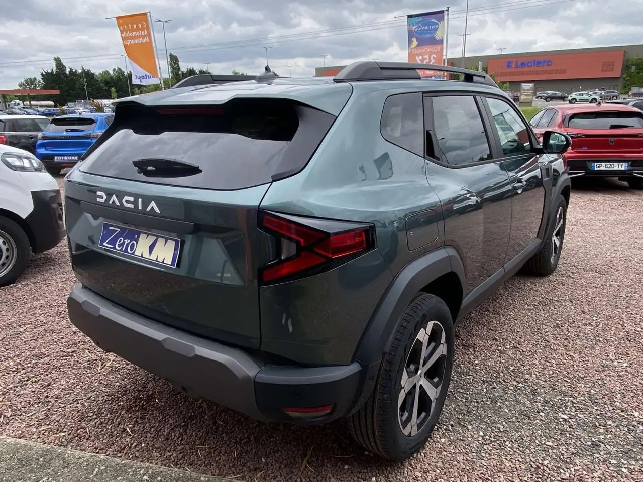 Vue 3/4 arrière droite du Dacia Duster 1.6 Hybrid 2025 en couleur INC avec jantes alliage et toit noir.