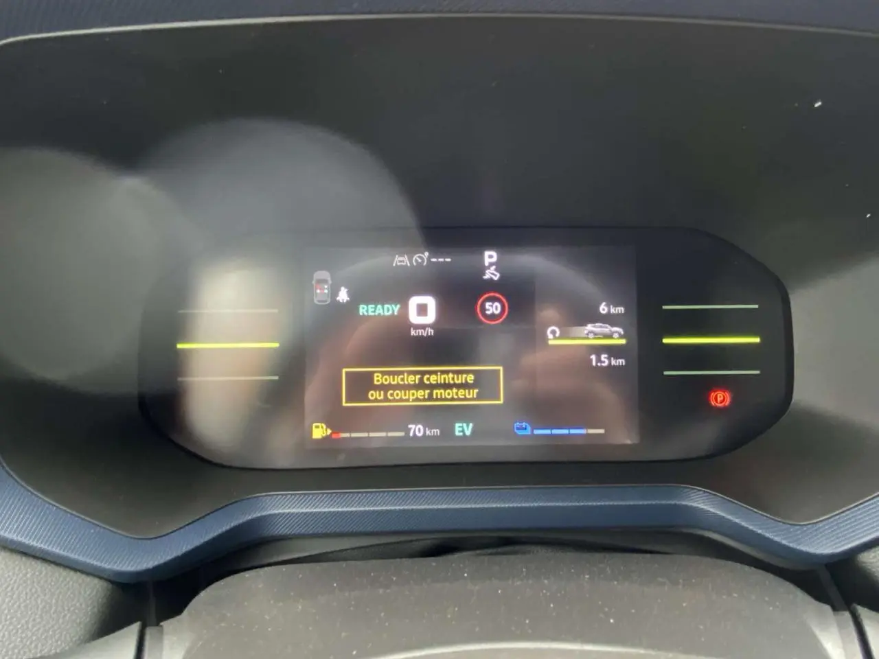 Vue rapprochée du tableau de bord numérique du Dacia Duster 2025, affichant l'écran de conduite en mode hybride.