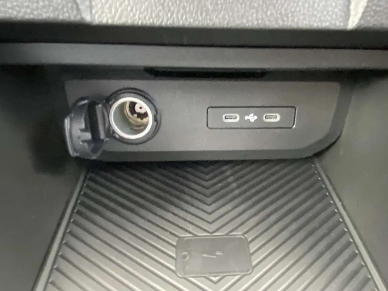 Prise allume-cigare et double port USB-C dans le rangement central du Dacia Duster 1.6 Hybrid 2025.