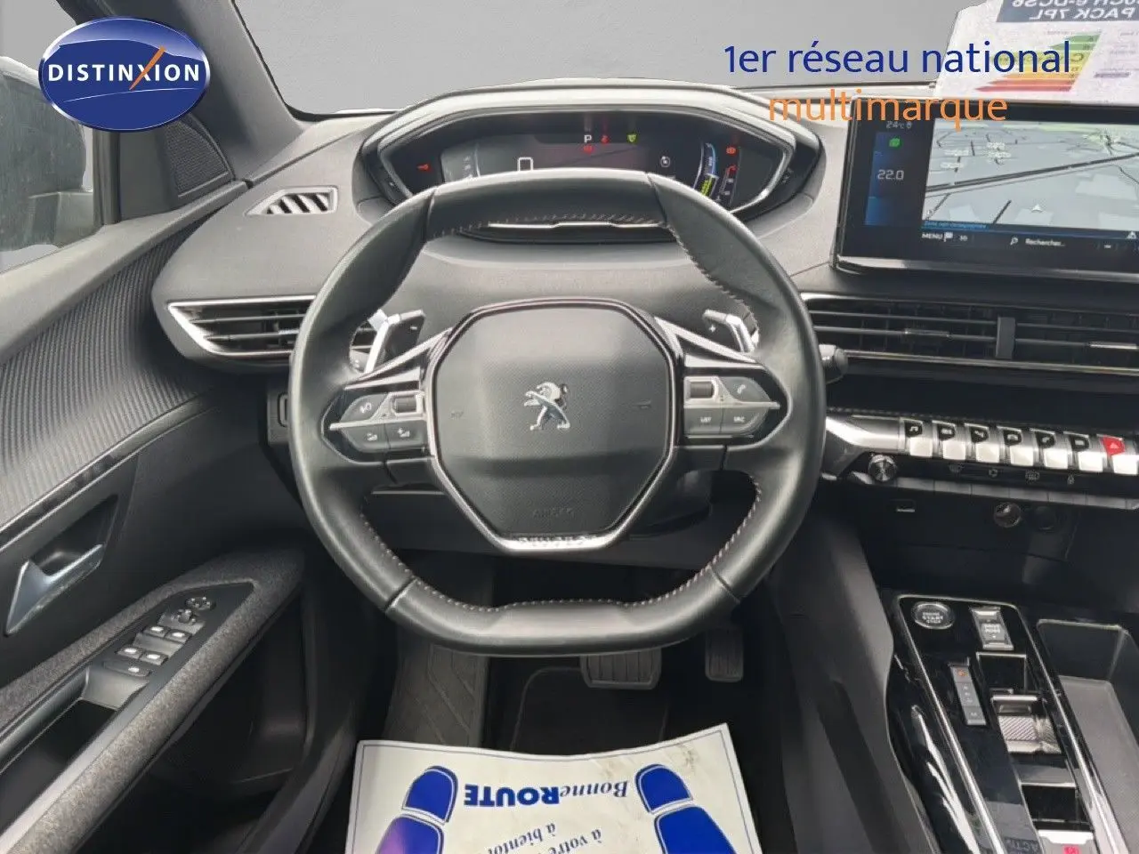 Vue intérieure centrée sur le volant cuir multifonction du Peugeot 5008 2024, tableau de bord et écran tactile visibles.
