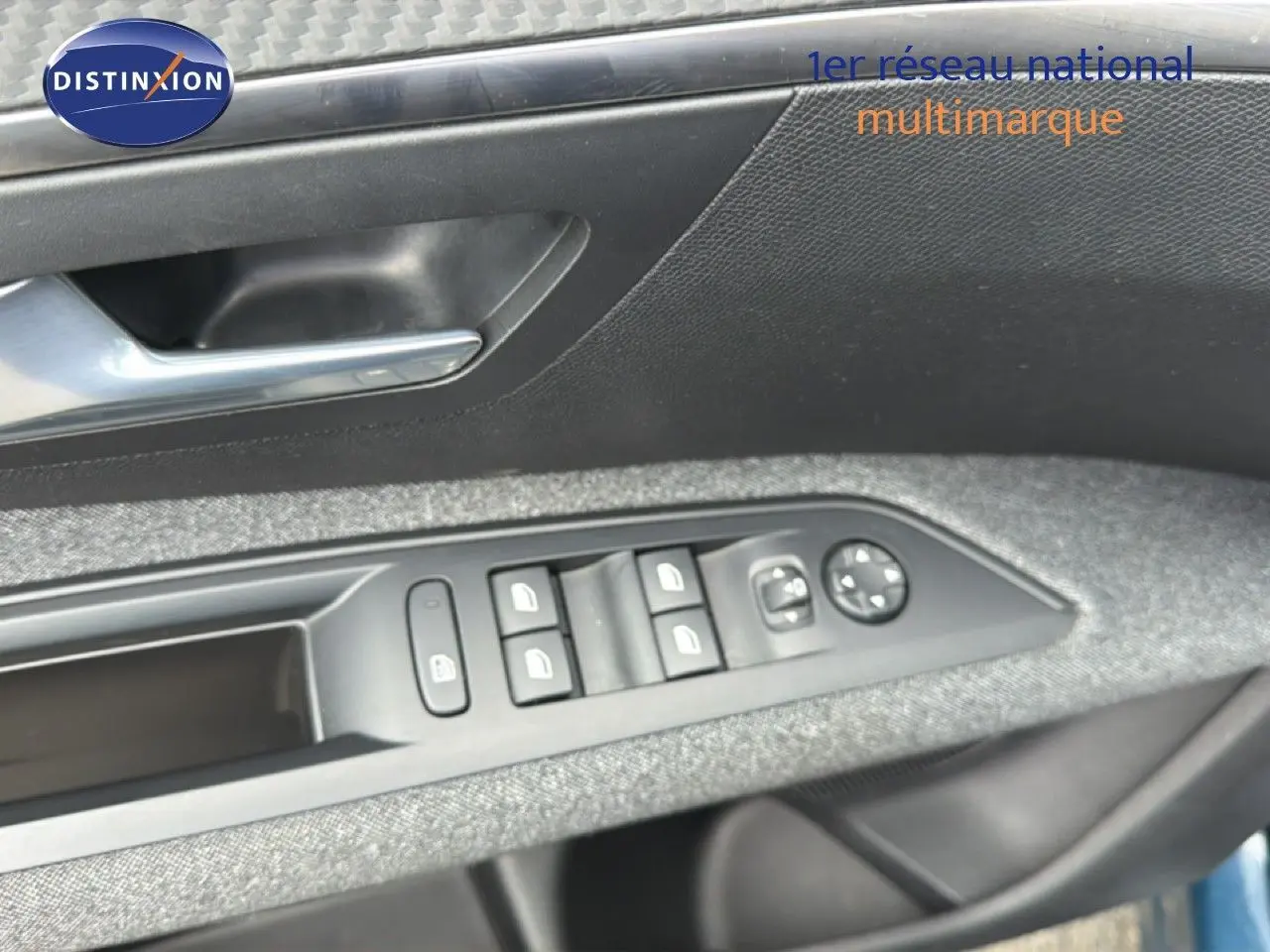 Détail des commandes de lève-vitres et rétroviseurs sur la porte côté conducteur d’un Peugeot 5008 bleu Celebes métal.