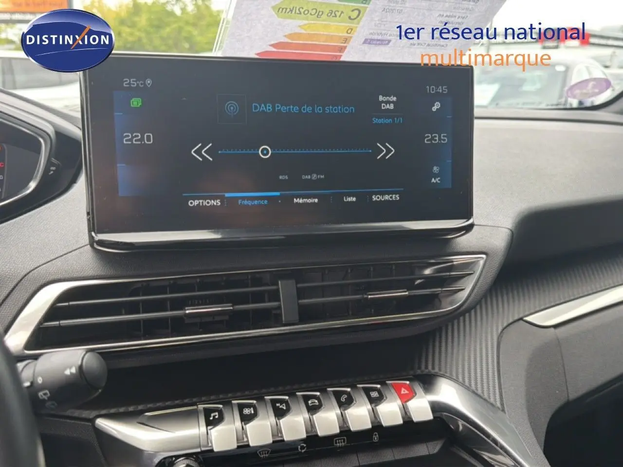 Vue intérieure du tableau de bord du Peugeot 5008 Hybrid 2024, écran tactile et commandes argentées sur fond noir.