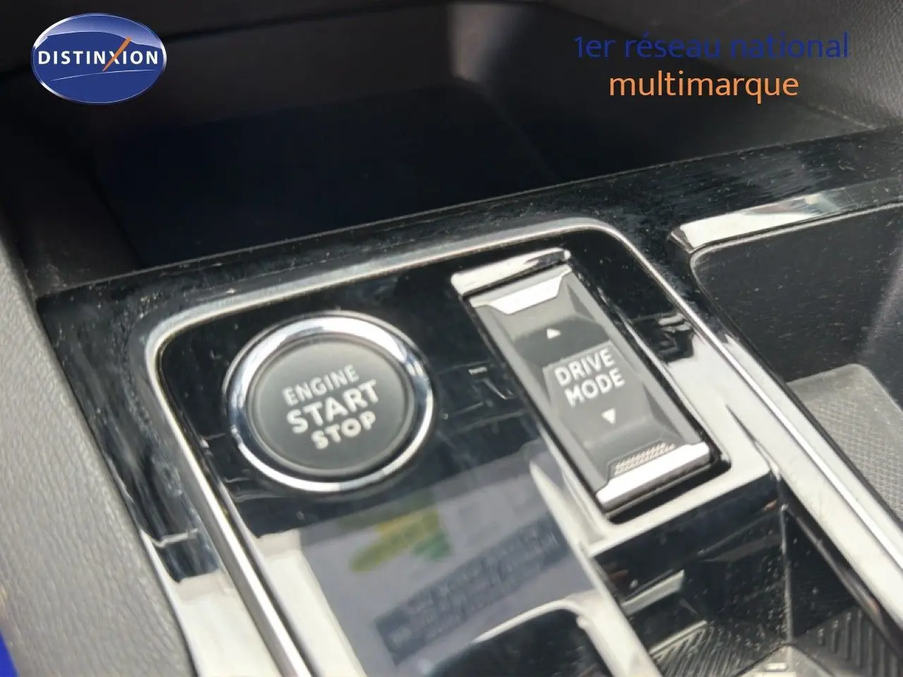 Gros plan sur la console centrale du Peugeot 5008 Hybrid 2024 avec bouton start/stop et commande drive mode.