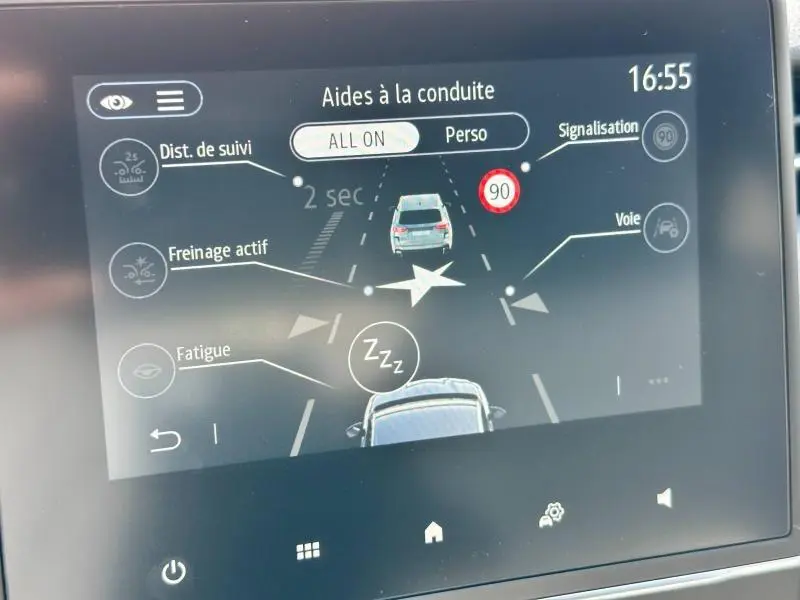 Écran tactile du système d'aides à la conduite de la Renault Clio blanche, affichant alertes et réglages en cours.
