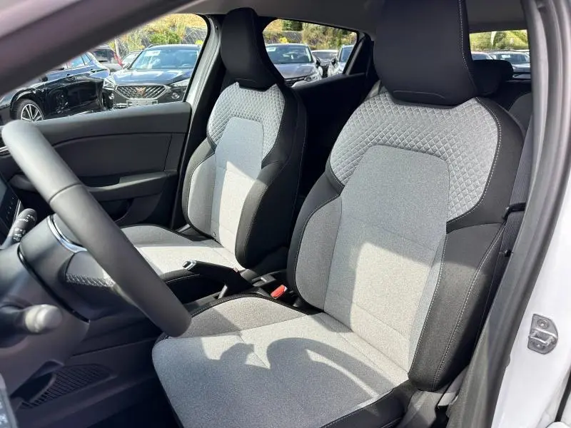 Vue intérieure côté conducteur de la Renault Clio 1.5 dCi 100ch Evolution 2025 avec sièges gris à motif 3D et volant multifonction.