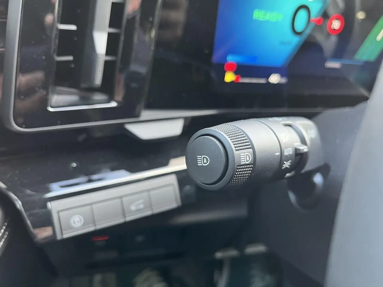 Gros plan sur la commande des feux et l’écran digital du tableau de bord du Renault Austral Ph.2 gris schiste.