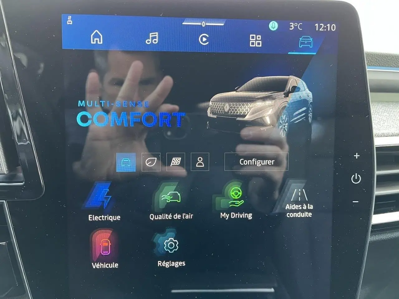 Écran tactile intérieur affichant le menu multimédia avec image du Renault Austral gris schiste en vue 3/4 avant.