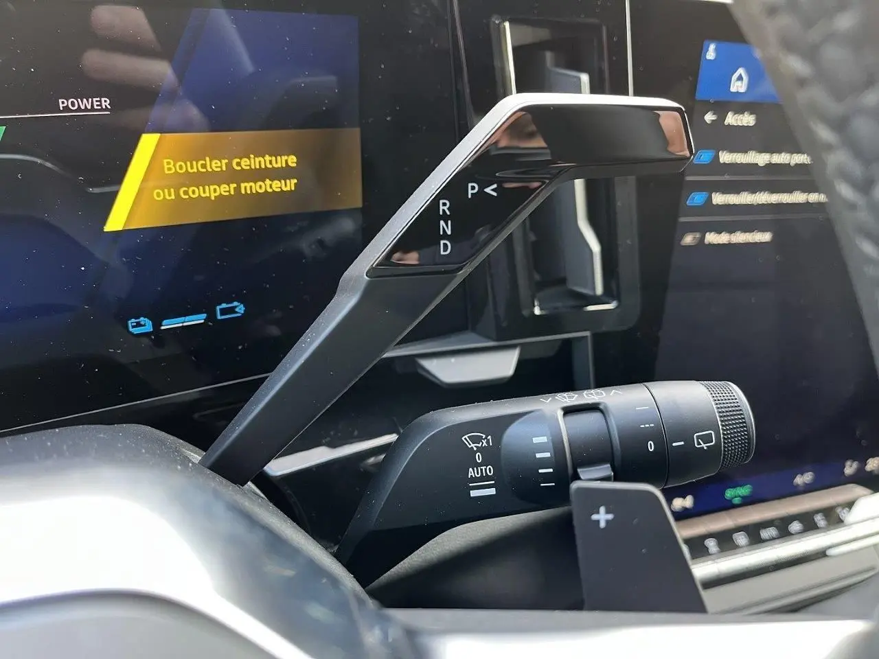 Gros plan sur la commande de boîte automatique et le commodo d’essuie-glace dans l’habitacle du Renault Austral gris schiste.