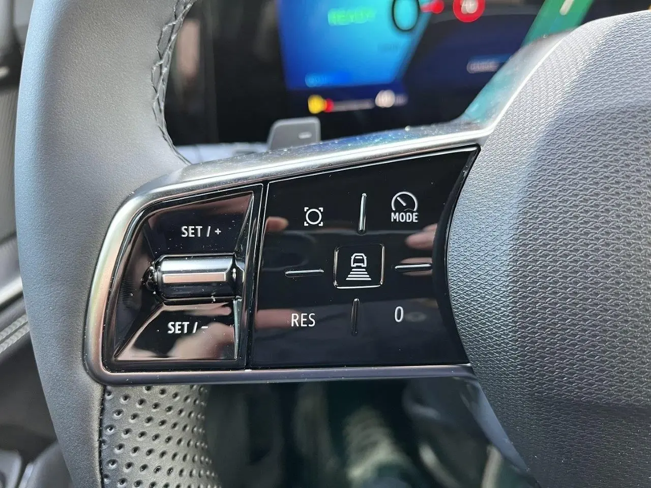 Gros plan sur les commandes gauche au volant du Renault Austral gris schiste, avec boutons de régulateur et mode de conduite.