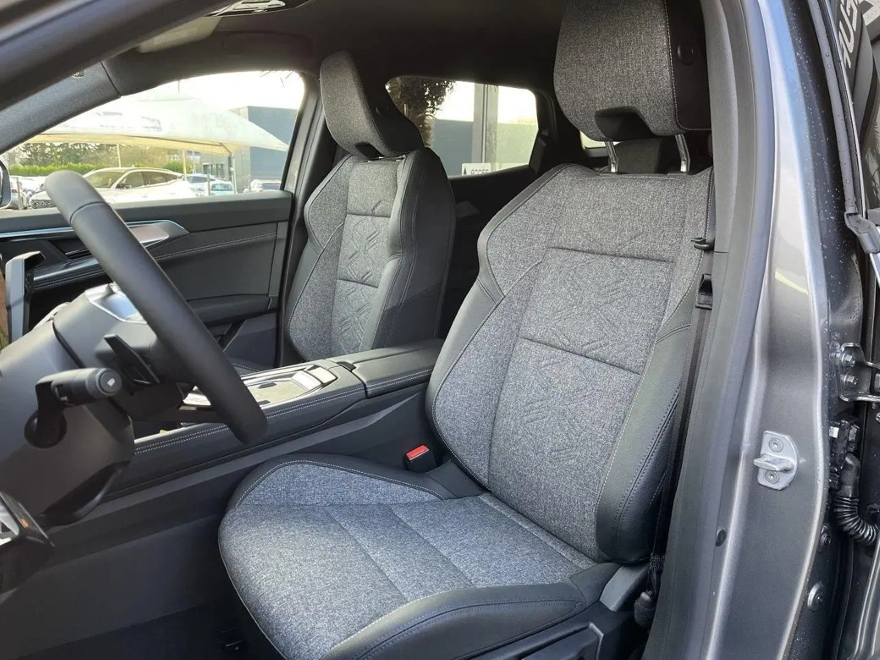 Vue intérieure côté conducteur du Renault Austral Ph.2 gris schiste, mettant en valeur les sièges tissu et cuir bi-matière.